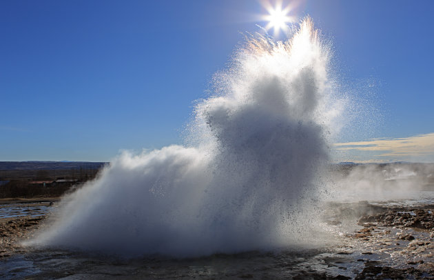 Geiser Strokkur spuugt water met tegenlicht in IJsland