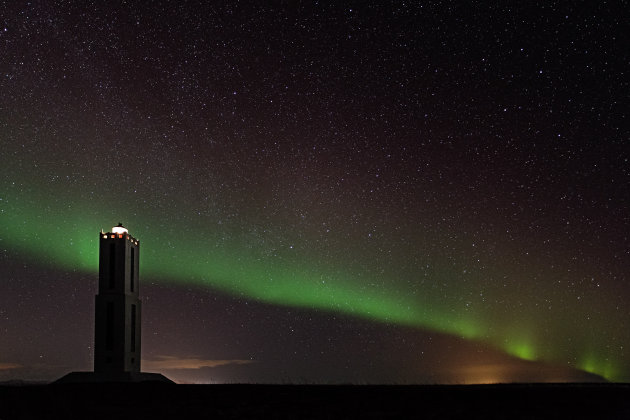 Aurora Borealis met vuurtoren in IJsland