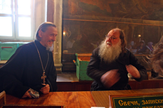 Russisch orthodoxe priesters delen boekjes voor de viering uit