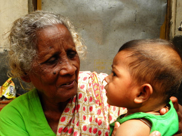 Oma met kleinkind in een sloppenwijk van Dhaka