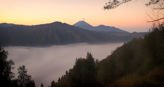 Mist, zonsopkomst en een rokende vulkaan