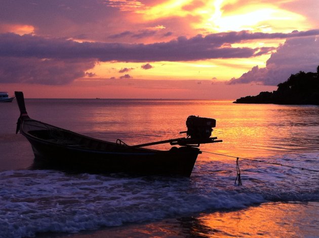 Verlaten vissersboot bij zonsondergang