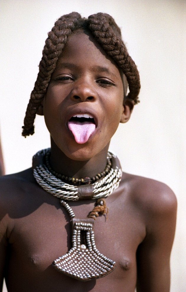 Himba jongen met uitstekende tong