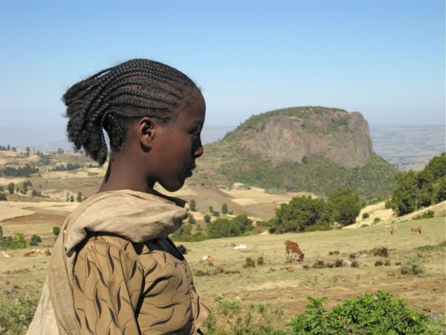 Meisje kijkt trots voor zich uit. Tafelberg op de achtergrond.