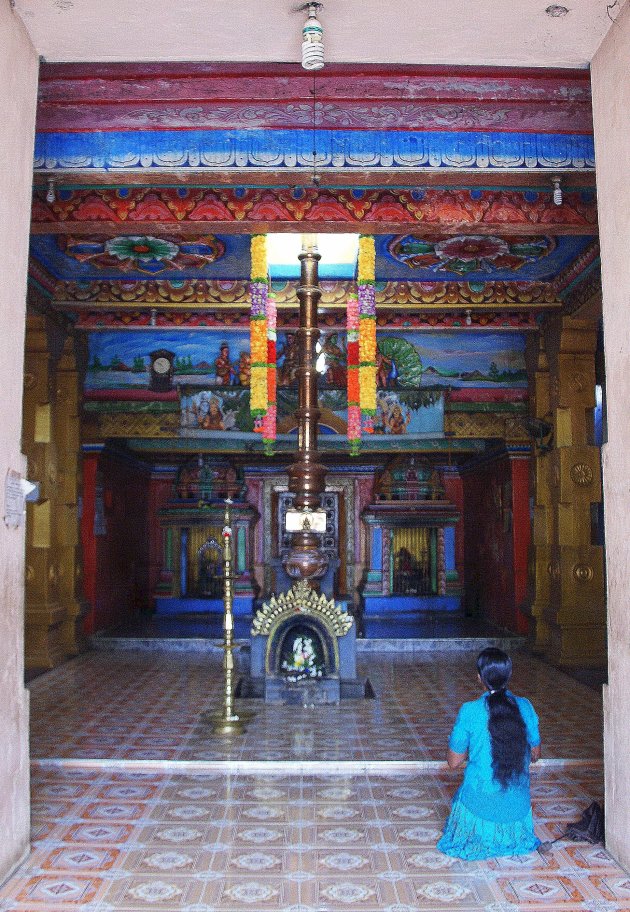 Hindu tempel met biddende vrouw