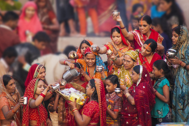 Vrouwen in het rood bij Chhath ceremonie