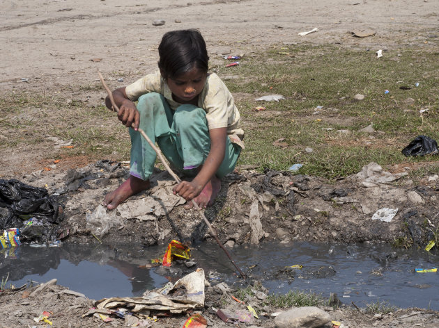 Mesje speelt bij een klein rioolstroompje -Nepal