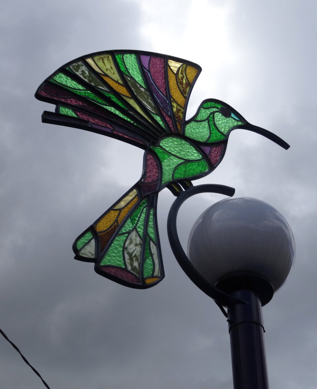 Een kolibrie op een lantaarnpaal