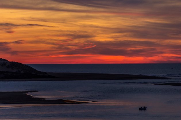 een eenzame visser tijdens de zonsondergang 