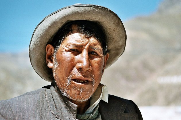 Oude Peruaanse man, met mooie hoed en doorleefd gezicht.