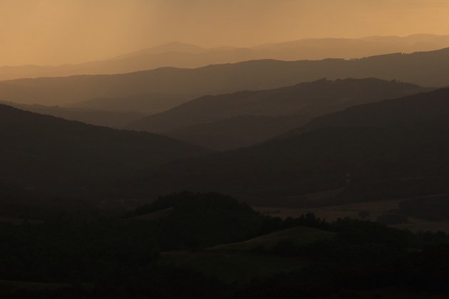 Heuvellandschap bij zonsondergang