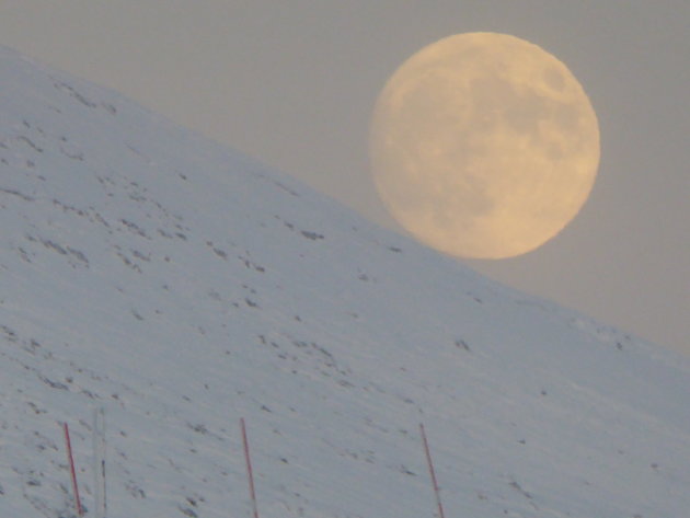 Op de Kongsfjordfjellet in winters Finnmark (noord Noorwegen) rolt de maan van de berghelling