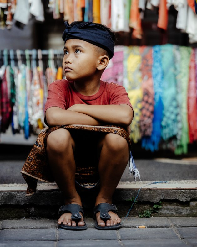 Jongetje rust uit op de toeristische markt van Ubud.