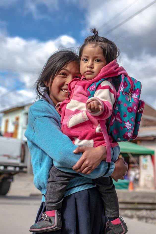 Een Ecuadoraans meisje heeft haar zusje van school opgehaald.