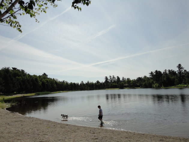 Kind en hond bij een meer in New Brunswick