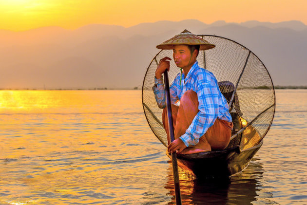 visser op zijn boot bij sunset